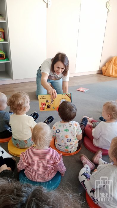 Biblioteka Gorlice, Pierwsze kroki… w świecie książek Bibliotekarka bawi sie z dziećmi zksiązką interaktywną